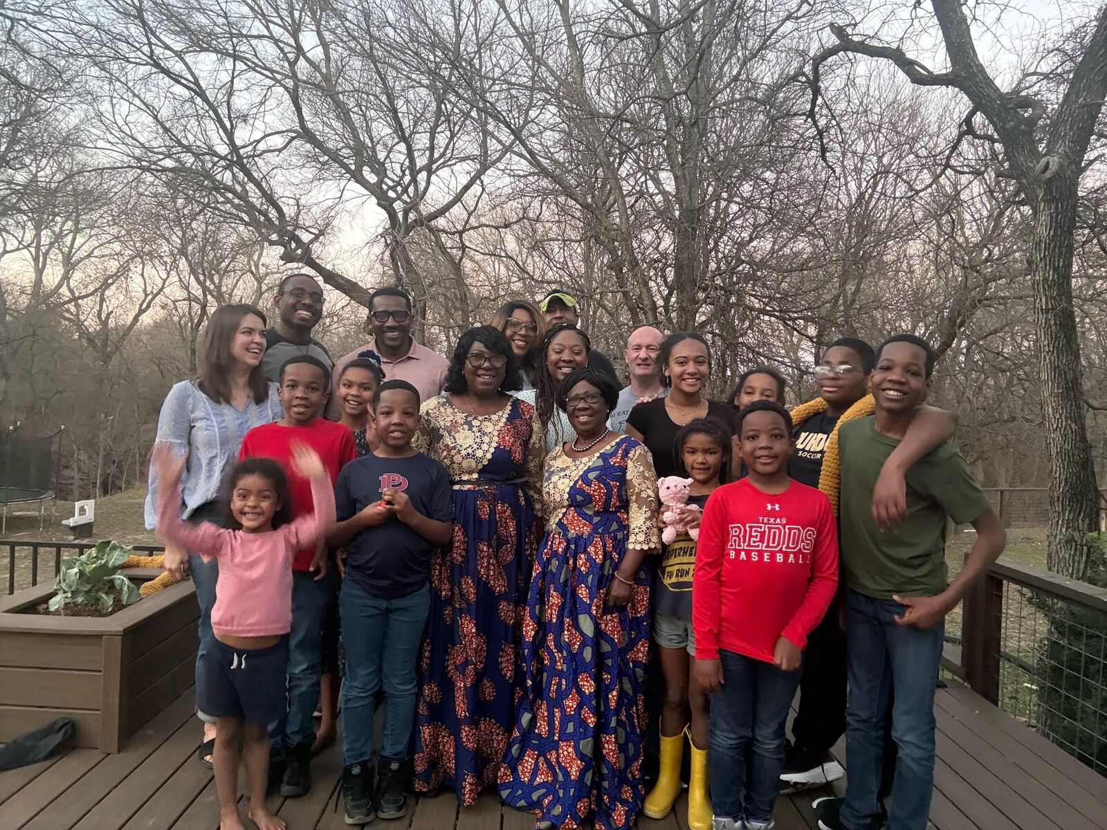 ACF Dallas families and children gathered on a backyard deck at sunset