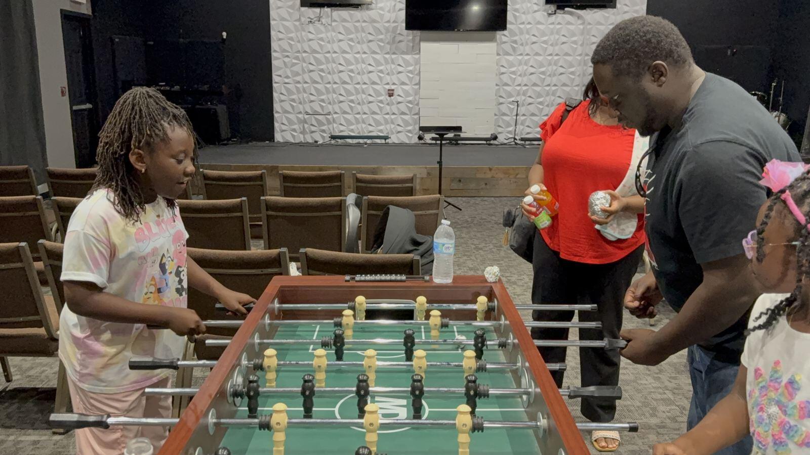 Kids and parents playing foosball after a gathering