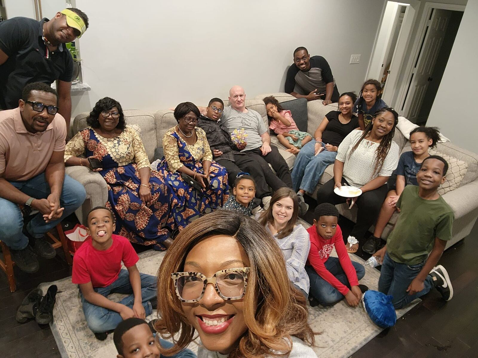A smiling selfie with ACF Dallas families and kids in a living room