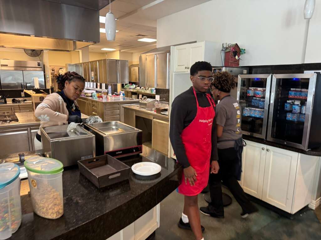 A young volunteer in an apron helping in a large kitchen