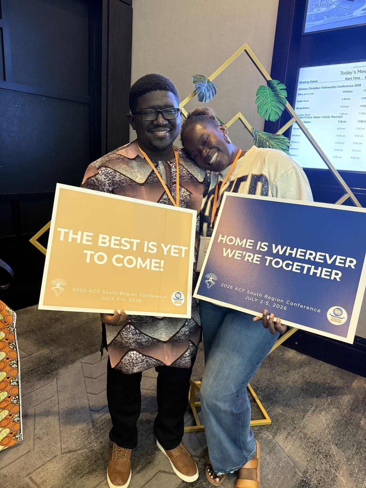 Two members holding signs reading The best is yet to come and Home is wherever we're together